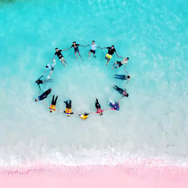 Foto Melingkar Bergandengan Di Bibir Pantai Pink Yang Cantik