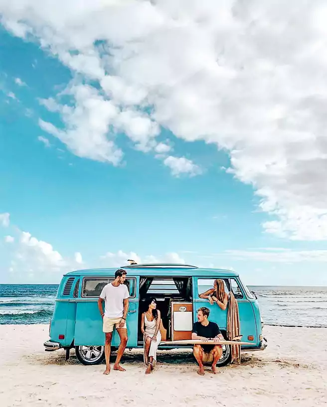 Foto Bersama Rombongan Wisata Di Depan Pantai Melasti Ungasan Dengan Atribut Mini Bus Biru
